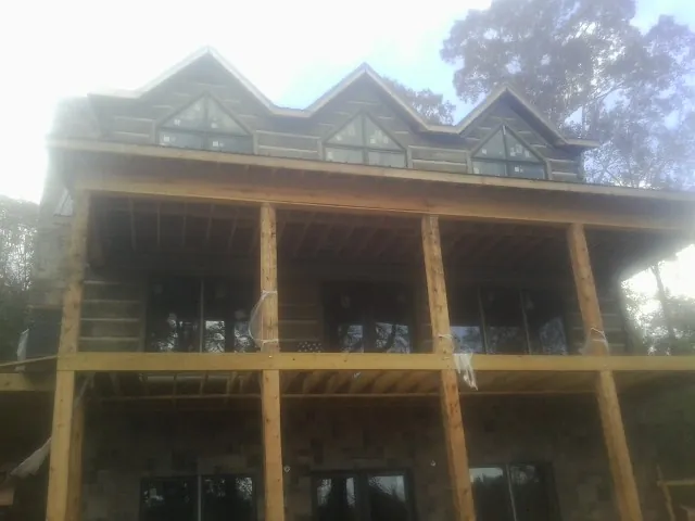 Dormers and porch framing on a large log home under construction — Roof Coating work by our crew in Coaldale