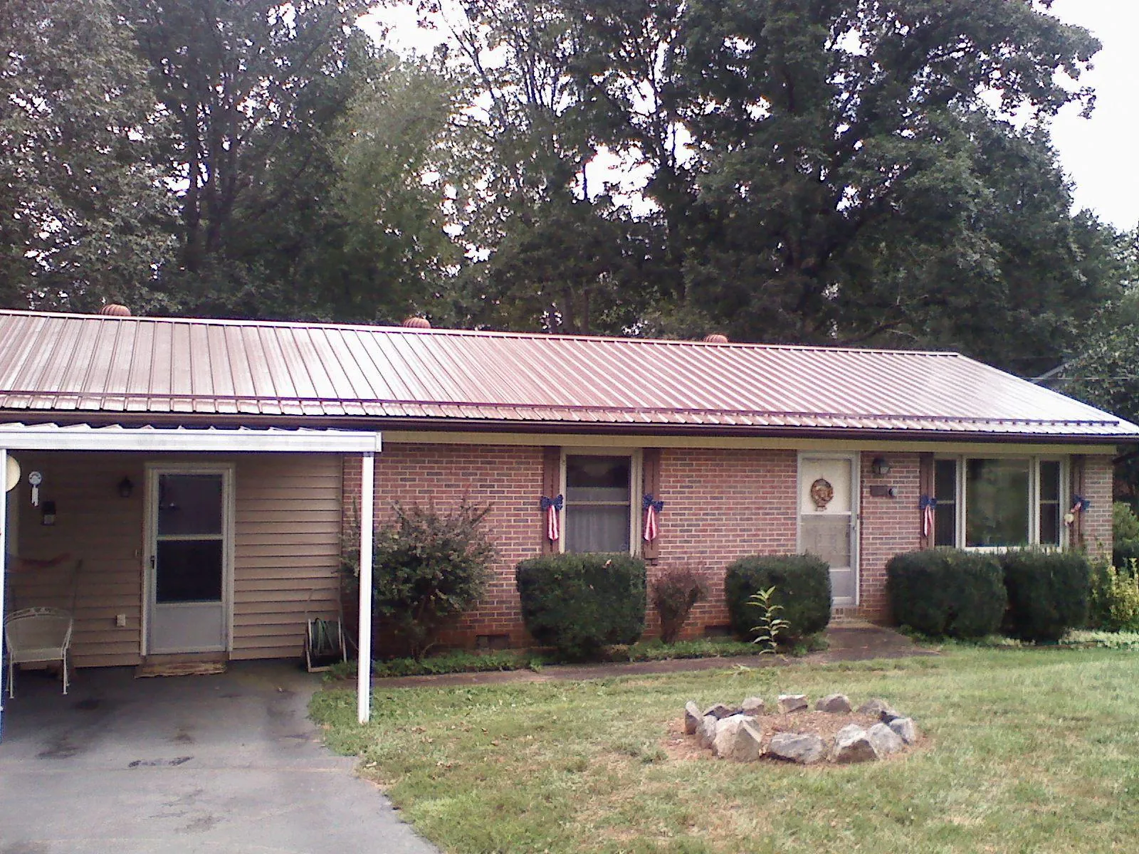 Bronze metal roof and carport on a brick ranch home — Roof Repair work by our crew in Coaldale